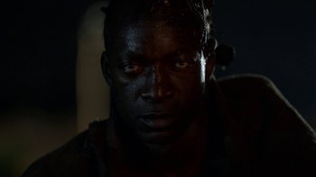 Movie still from “Oats Studios” (2017), directed by Neill Blomkamp – A man's face in the dark; Close Up shot, Over the shoulder angle