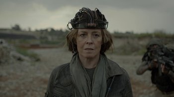 Movie still from “Oats Studios” (2017), directed by Neill Blomkamp – A woman wearing a hat with wires on top of her head; Close Up shot, Low angle