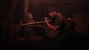 Movie still from “Oats Studios” (2017), directed by Neill Blomkamp – A man holding a baseball bat while standing in a room; Wide shot, Low angle