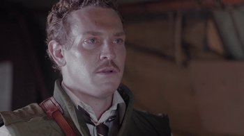 Movie still from “Oats Studios” (2017), directed by Neill Blomkamp – A person wearing a suit and tie; Close Up shot, Low angle