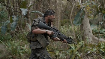 Movie still from “Oats Studios” (2017), directed by Neill Blomkamp – A man holding a gun in the woods; Medium shot, Low angle