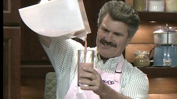 Movie still from “Oats Studios” (2017), directed by Neill Blomkamp – A man holding a glass of milk in his hand; Medium shot, High angle