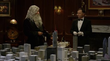 Movie still from “Oats Studios” (2017), directed by Neill Blomkamp – Two men standing in front of a model of a city; Medium shot, Over the shoulder angle
