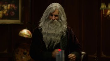 Movie still from “Oats Studios” (2017), directed by Neill Blomkamp – An old man with long white hair and a long beard; Close Up shot, Over the shoulder angle