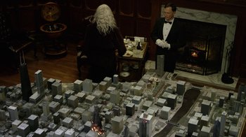 Movie still from “Oats Studios” (2017), directed by Neill Blomkamp – Two people standing in front of a model of a city; Wide shot, High angle