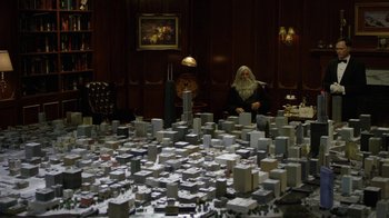 Movie still from “Oats Studios” (2017), directed by Neill Blomkamp – An old man sitting in front of a model of a city; Wide shot, High angle