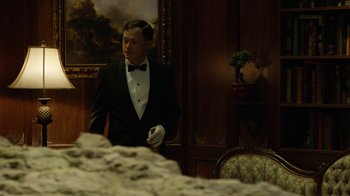 Movie still from “Oats Studios” (2017), directed by Neill Blomkamp – A man in a tuxedo standing next to a table; Medium shot, Over the shoulder angle