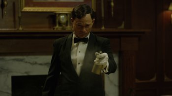 Movie still from “Oats Studios” (2017), directed by Neill Blomkamp – A man in a tuxedo holding a white glove; Close Up shot, Low angle