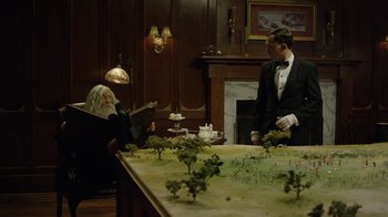 Movie still from “Oats Studios” (2017), directed by Neill Blomkamp – A man in a suit standing next to a man in a black suit; Wide shot, High angle