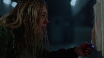 Movie still from “Oats Studios” (2017), directed by Neill Blomkamp – A woman with long blonde hair looking at something in the dark; Close Up shot, Over the shoulder angle