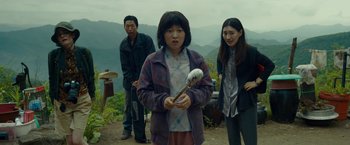 Movie still from “Okja” (2017), directed by Bong Joon Ho – A group of people standing on top of a hill; Medium shot, Over the shoulder angle