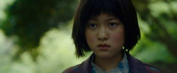 Movie still from “Okja” (2017), directed by Bong Joon Ho – A person with short black hair; Close Up shot, Low angle