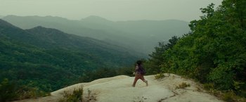 Movie still from “Okja” (2017), directed by Bong Joon Ho – A woman walking on a trail in the mountains; Extreme Wide shot, High angle