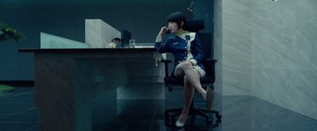 Movie still from “Okja” (2017), directed by Bong Joon Ho – A woman sitting in a chair in front of a computer desk; Medium shot, Over the shoulder angle