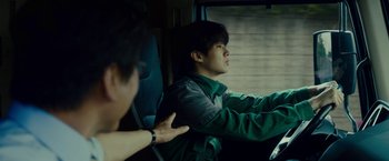 Movie still from “Okja” (2017), directed by Bong Joon Ho – A man sitting in the back seat of a car; Close Up shot, Over the shoulder angle