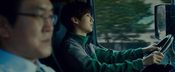 Movie still from “Okja” (2017), directed by Bong Joon Ho – A man sitting in the driver's seat of a car; Close Up shot, Low angle