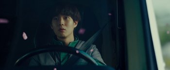 Movie still from “Okja” (2017), directed by Bong Joon Ho – A man sitting in the driver's seat of a car; Close Up shot, Low angle