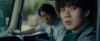 Movie still from “Okja” (2017), directed by Bong Joon Ho – Two young men sitting in the back seat of a car; Close Up shot, Over the shoulder angle