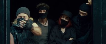 Movie still from “Okja” (2017), directed by Bong Joon Ho – A man and a woman wearing black masks; Medium shot, Overhead angle