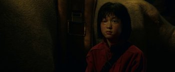 Movie still from “Okja” (2017), directed by Bong Joon Ho – A young girl in a red shirt is looking at the camera; Close Up shot, High angle