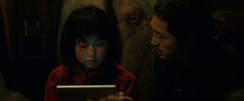 Movie still from “Okja” (2017), directed by Bong Joon Ho – A man and a child looking at an ipad; Close Up shot, Over the shoulder angle