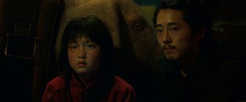 Movie still from “Okja” (2017), directed by Bong Joon Ho – A man and a woman standing next to an elephant; Close Up shot, Low angle