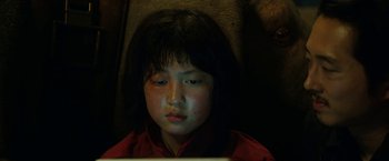 Movie still from “Okja” (2017), directed by Bong Joon Ho – A young girl sitting in front of a laptop computer; Close Up shot, High angle