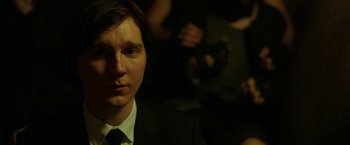 Movie still from “Okja” (2017), directed by Bong Joon Ho – A man wearing a suit and tie in front of a camera; Close Up shot, Over the shoulder angle