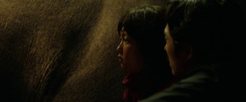 Movie still from “Okja” (2017), directed by Bong Joon Ho – A woman in a red shirt is looking to the side; Close Up shot, Over the shoulder angle