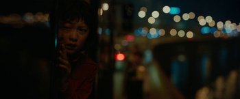 Movie still from “Okja” (2017), directed by Bong Joon Ho – A young girl standing next to a street at night; Close Up shot, Low angle