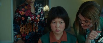 Movie still from “Okja” (2017), directed by Bong Joon Ho – A young asian girl with short black hair and wearing a green shirt; Close Up shot, Over the shoulder angle