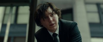 Movie still from “Okja” (2017), directed by Bong Joon Ho – A person wearing a suit and tie; Close Up shot, Over the shoulder angle