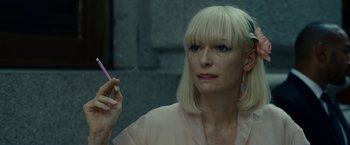 Movie still from “Okja” (2017), directed by Bong Joon Ho – A woman holding a cigarette in her right hand; Close Up shot, Over the shoulder angle