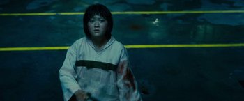Movie still from “Okja” (2017), directed by Bong Joon Ho – A young girl with blood on her shirt and a tennis racquet; Medium shot, High angle