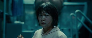 Movie still from “Okja” (2017), directed by Bong Joon Ho – A young asian girl in a white shirt and black hair; Close Up shot, Low angle