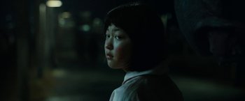 Movie still from “Okja” (2017), directed by Bong Joon Ho – A young girl is looking into the distance at night; Close Up shot, Over the shoulder angle