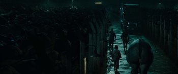 Movie still from “Okja” (2017), directed by Bong Joon Ho – A group of people walking down a street at night; Extreme Wide shot, Over the shoulder angle