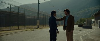 Movie still from “Okja” (2017), directed by Bong Joon Ho – Two men standing on the side of the road talking; Medium shot, Over the shoulder angle