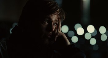 Movie still from “Moneyball” (2011), directed by Bennett Miller – A man with his hand to his face in the dark; Close Up shot, Over the shoulder angle