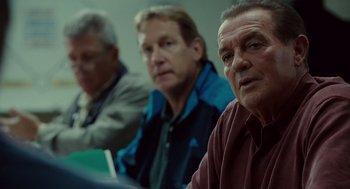Movie still from “Moneyball” (2011), directed by Bennett Miller – A group of men sitting next to each other in a room; Close Up shot, Over the shoulder angle