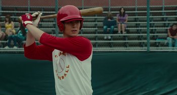 Movie still from “Moneyball” (2011), directed by Bennett Miller – A baseball player holding a baseball bat on top of a baseball field; Medium shot, Over the shoulder angle