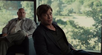 Movie still from “Moneyball” (2011), directed by Bennett Miller – A man sitting on a bus next to another man; Medium shot, Over the shoulder angle