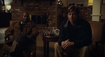 Movie still from “Moneyball” (2011), directed by Bennett Miller – Two men sitting in a living room next to each other; Medium shot, Over the shoulder angle