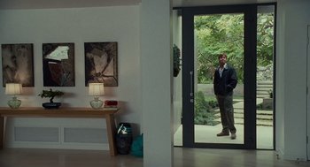 Movie still from “Moneyball” (2011), directed by Bennett Miller – A man standing in front of an open glass door; Wide shot, Over the shoulder angle