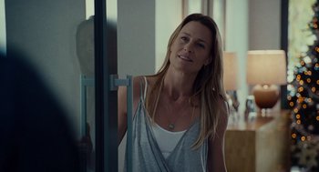 A woman standing in front of a glass door