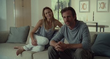 Movie still from “Moneyball” (2011), directed by Bennett Miller – A man and a woman sitting on a couch in front of a window; Medium shot, Over the shoulder angle