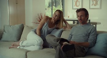 Movie still from “Moneyball” (2011), directed by Bennett Miller – A man and a woman sitting on a couch together; Medium shot, Low angle