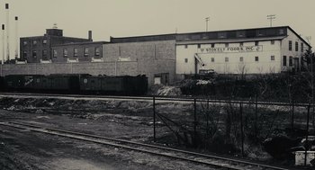 Movie still from “Moneyball” (2011), directed by Bennett Miller – An old photo of an industrial building and a train track; Extreme Wide shot, High angle