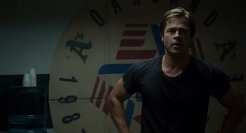 Movie still from “Moneyball” (2011), directed by Bennett Miller – A man standing in front of a wall with a clock; Medium shot, Over the shoulder angle
