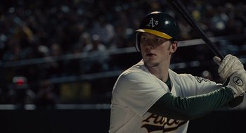 Movie still from “Moneyball” (2011), directed by Bennett Miller – A baseball player holding a baseball bat during a baseball game; Close Up shot, Low angle